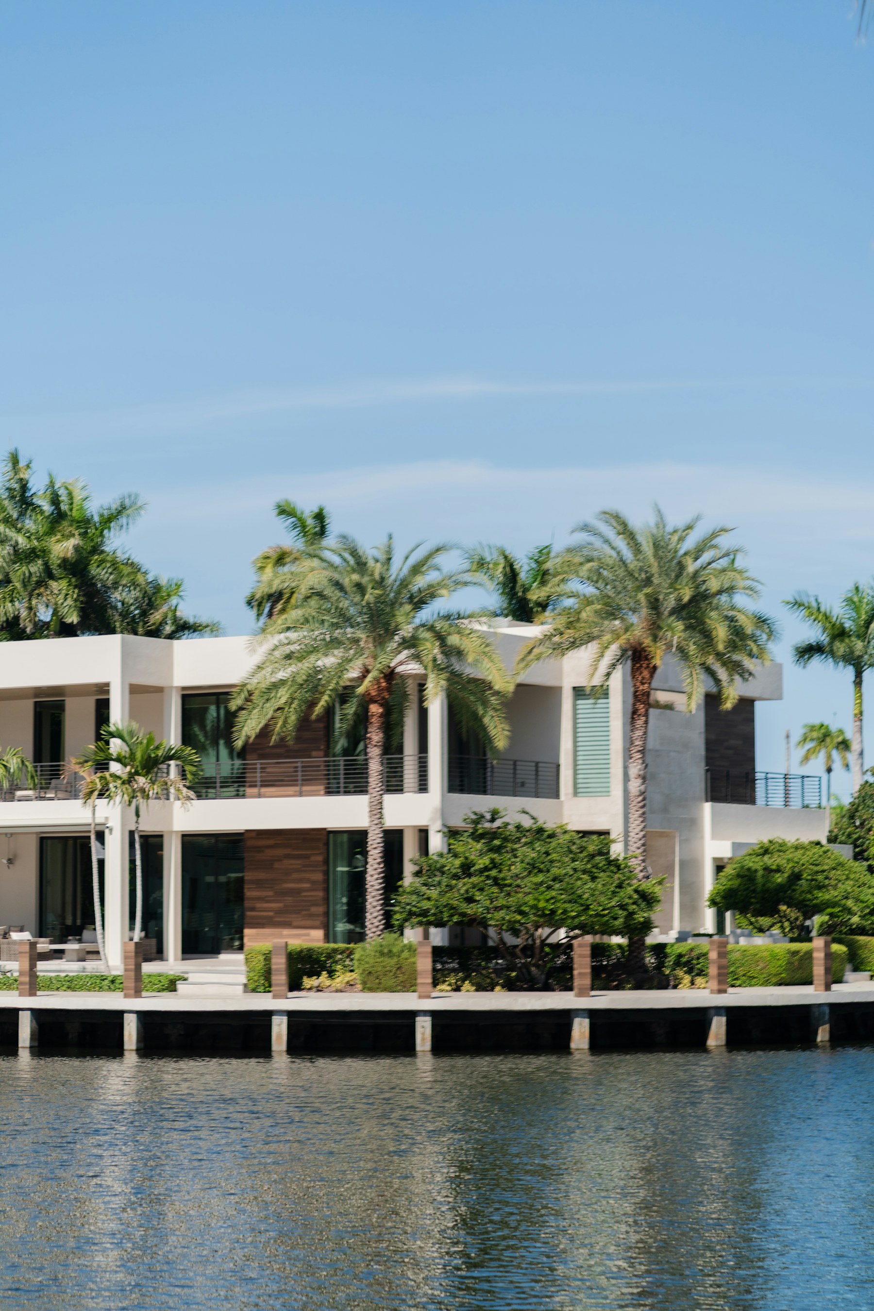 Modern South Florida waterfront home framed by palm trees